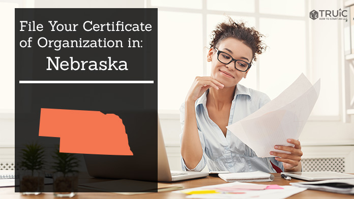 Woman smiling while looking at her certificate of organization for Nebraska.