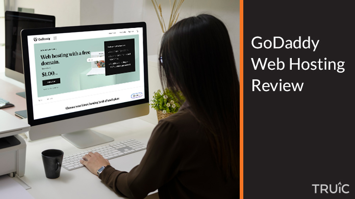 Woman on laptop looking at GoDaddy web hosting.