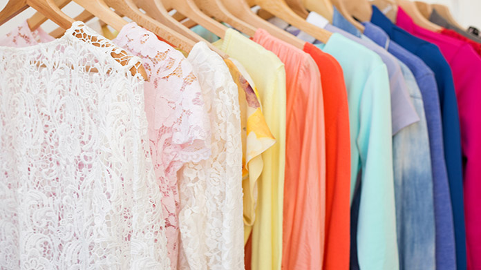 a clothing rack with an assortment of colorful clothing.