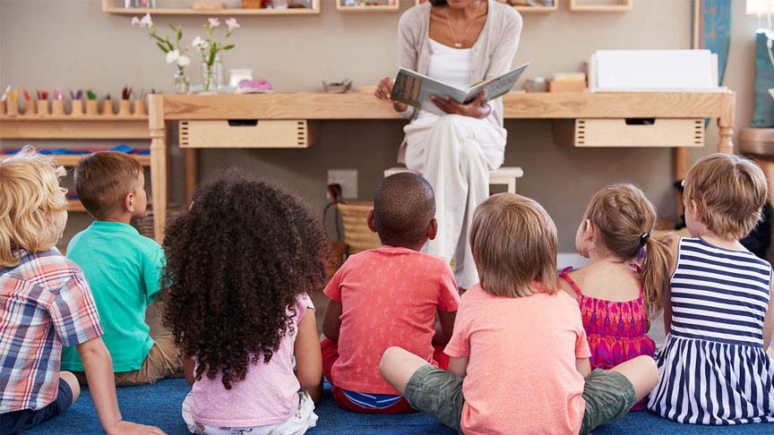 Image of woman reading to group of young children.