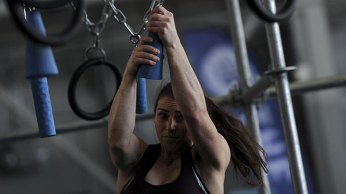 A woman working our at a ninja warrior gym
