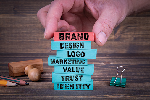 Stack of branding words on wood blocks: brand, logo, design, marketing, value, trust, and identity.