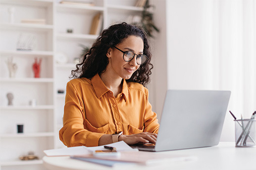 Woman looking at a computer and reading an article about EINs.