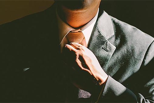 Close-up of a man straightening his tie