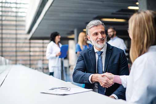 Man and woman shaking hands in a business setting.