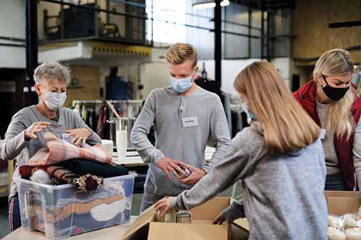 Group of nonprofit volunteers gathering clothing and food donations